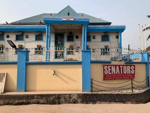 Un edificio con un cartel en el costado. en SENATOR'S SUITES and TOWERS HOTEL, en Agege