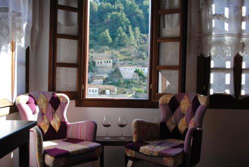 two chairs and a table with two glasses of wine at White House Boutique Hotel & Restaurant - since 1999 in Berat