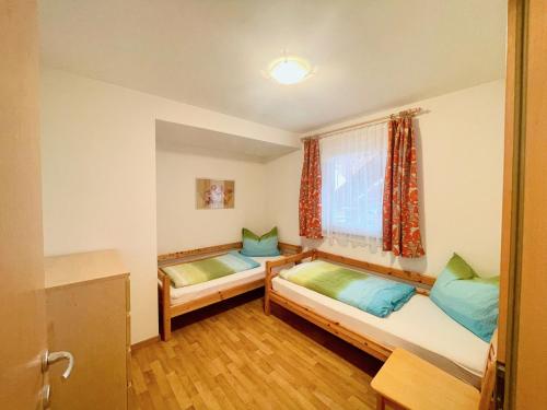 a room with two beds and a window at FeWo Ortler auf dem Familien- & Tierfreundlichen Haslinger Hof in Saltusio
