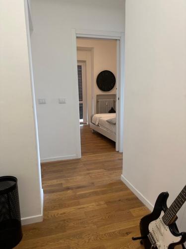 a room with a guitar and a bedroom with a bed at Centro Lecco Piazza Manzoni in Lecco