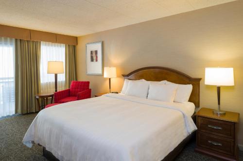 a hotel room with a large bed and a red chair at Toftrees Golf Resort in State College