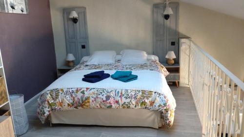 une chambre avec un lit avec des serviettes bleues dessus dans l'établissement Joli duplex-mezzanine à Amélie-les-Bains, à Amélie-les-Bains-Palalda