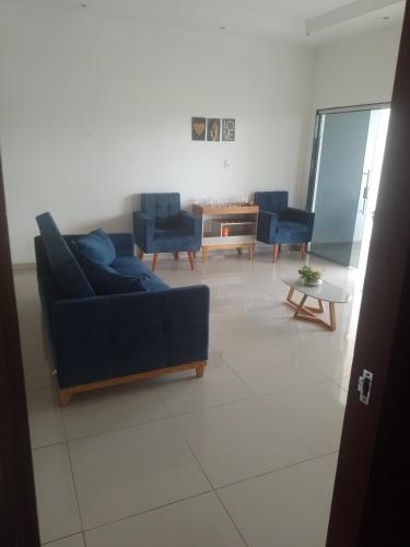 a living room with blue couches and a table at Pousada Maria Bonita in Macau