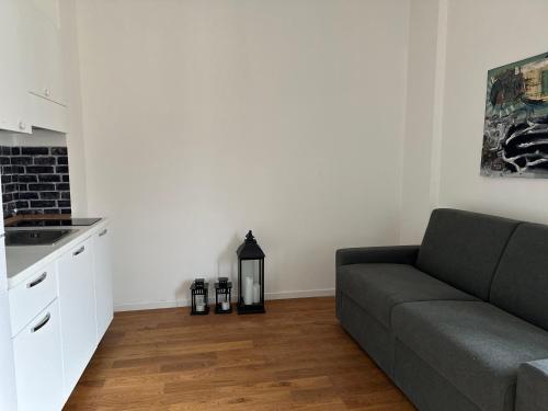 a living room with a couch and a kitchen at Centro Lecco Piazza Manzoni in Lecco
