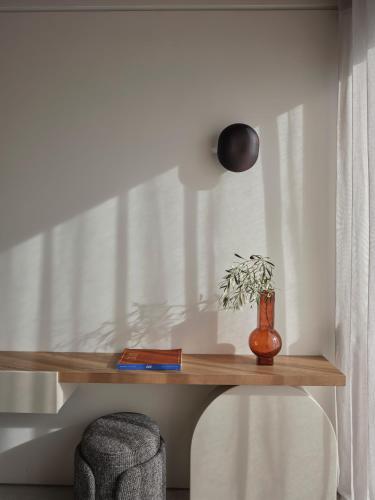 a wooden shelf with a vase and a plant on it at Noero Villas Lefkada in Lefkada Town