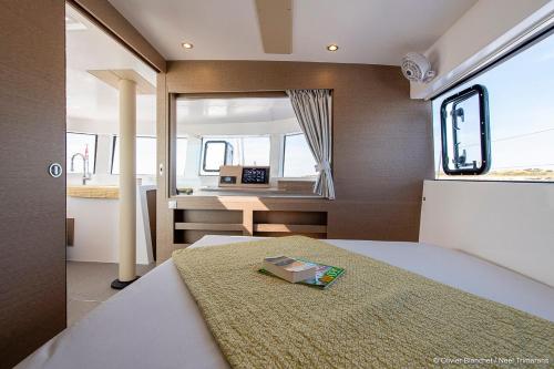 une chambre avec un lit et un bureau dans l'établissement Croisière Privée sur le trimaran TRIKALA, à La Grande Motte