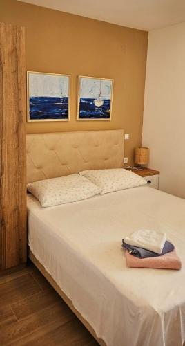 a bedroom with a bed with two pictures on the wall at Villa Pepo in Cavtat