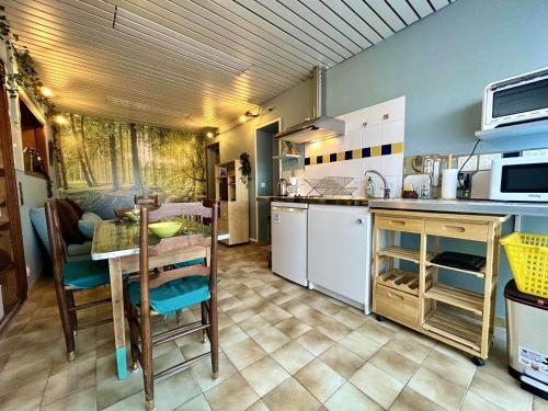 une cuisine avec une table et une salle à manger dans l'établissement Maison 2 pièces 3 couchages Saint Pierre d'Oléron SPO000-061, à Saint-Pierre-dʼOléron