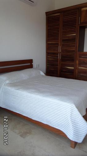 a bedroom with two beds and wooden cabinets at Mansiones Cruz del Mar Huatulco in Santa Cruz Huatulco