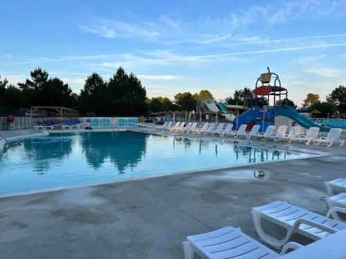 une grande piscine avec des chaises et un toboggan dans l'établissement MH 477 CASITA 3 chambres 1 salle de bain dans camping 4 étoiles avec parc aquatique, à Saint-Julien-en-Born