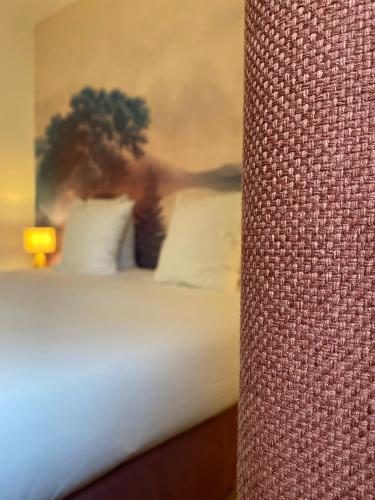 a close up of a bed with white pillows at Logis Hôtel Médiéval, Montélimar Nord in Rochemaure