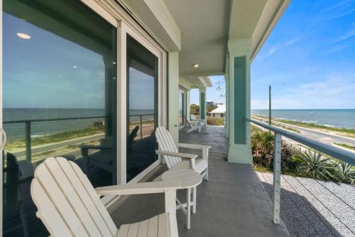 two chairs on a porch with a view of the ocean at Oceanshore Oasis in Flagler Beach