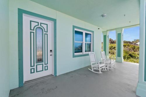 a room with two chairs and a door with windows at Oceanshore Oasis in Flagler Beach