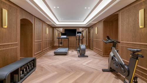a gym with exercise equipment in a room with wooden walls at Santo Mauro, a Luxury Collection Hotel, Madrid in Madrid