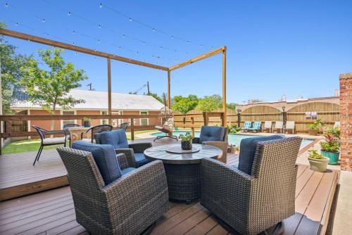 a patio with wicker chairs and a table on a deck at The Eastland Historic Hotel- Imperial Room in Eastland