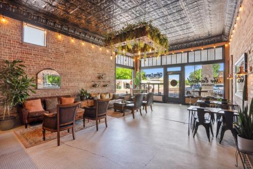 a restaurant with tables and chairs and a brick wall at The Eastland Historic Hotel- Hondo Room in Eastland