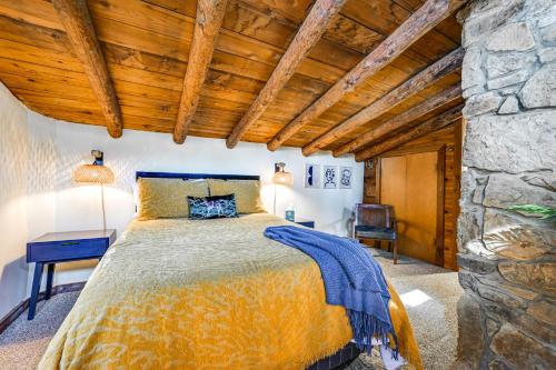 a bedroom with a bed and a stone wall at Log Cabin Retreat in Kentucky Fire Pit and Grill! in Owensboro