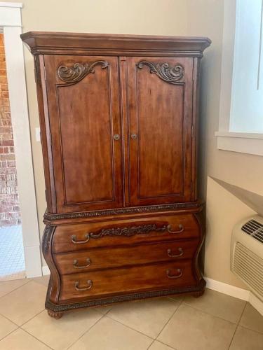 a wooden dresser sitting in a room at The Justin Room at The Eastland Historic Hotel in Eastland