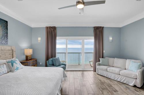 オレンジビーチにあるEscapes to the Shores Penthouse 1803のベッドとソファと窓のある寝室