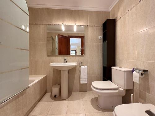 a bathroom with a white toilet and a sink at Cinco Soles - 5927 in Isla