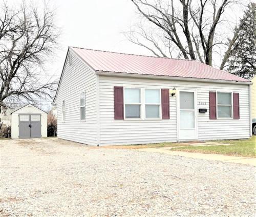 a white house with a red roof and a driveway at Pontiac - Secluded Backyard, Pet Friendly in Fort Wayne