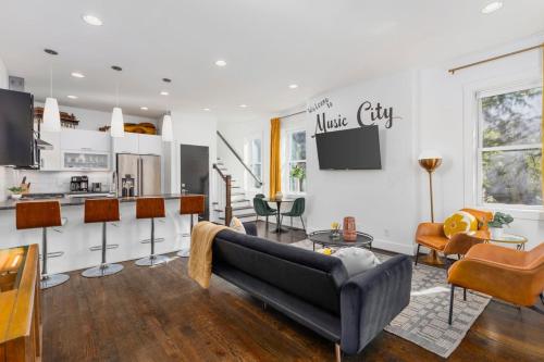 a living room with a couch and a kitchen at TWO Adjacent Homes in 12 South and Belmont area Sleeps 20 People in Nashville