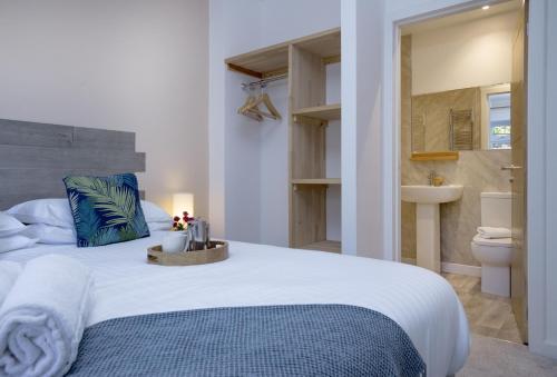 a bedroom with a large bed and a bathroom at Fernwood in Totnes