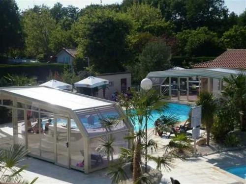 une maison avec piscine à côté d'une maison dans l'établissement Camping 4 étoiles - Parc aquatique - ccb0bcc, à Saint-Sauveur