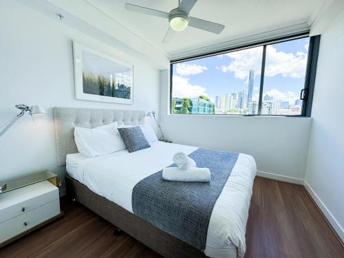 a bedroom with a bed and a large window at Apartments on Connor in Brisbane