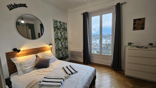une chambre avec un lit avec un miroir et une fenêtre dans l'établissement Studio calme, piscine - Proche thermes et centre, à Aix-les-Bains