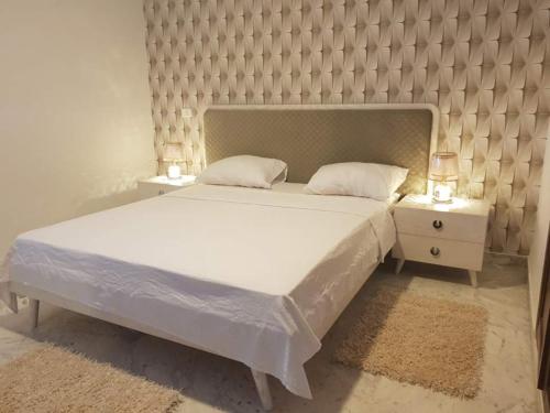 a bedroom with a large bed and two night stands at Lovely apartment near Tunis Mall - Lac2 Tunis in Tunis