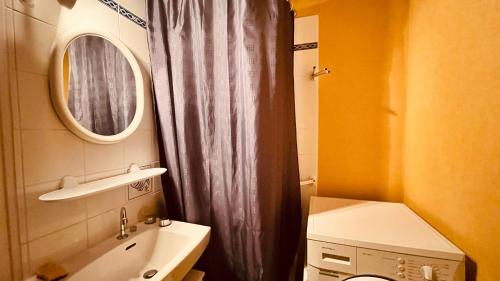 une salle de bain avec un lavabo, des toilettes et un miroir dans l'établissement Le Saint Hilaire vue océan, à Saint-Hilaire-de-Riez