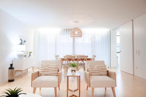 a white living room with a table and chairs at Emerald Wave Oasis in Ponta Delgada