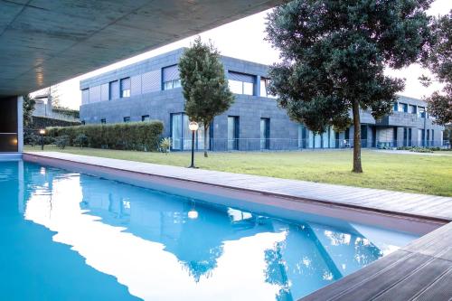 a swimming pool in front of a building at Emerald Wave Oasis in Ponta Delgada