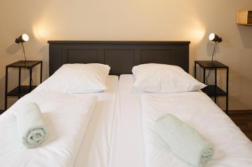 two beds with white sheets and pillows at Wombat's City Hostel Leipzig in Leipzig