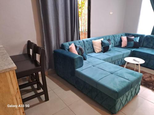 a living room with a blue couch and a table at The Little Cave in Livingstone
