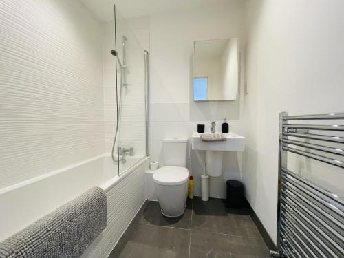 a white bathroom with a toilet and a sink at Southernhay Court Apartments by Staytor Accommodation in Exeter