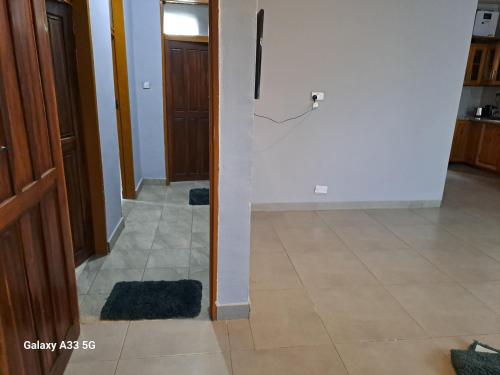 a hallway with a door and a tile floor at The Little Cave in Livingstone