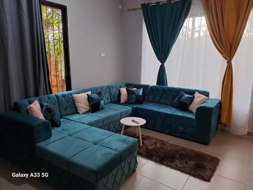 a living room with a blue couch and a table at The Little Cave in Livingstone