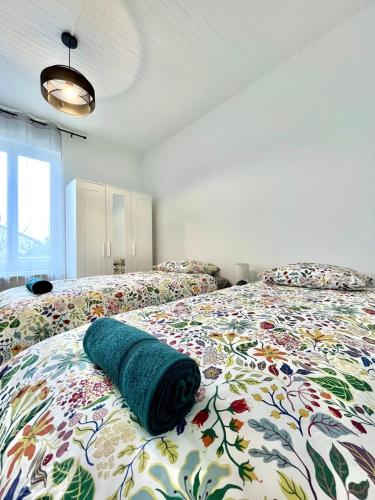 a bedroom with two beds with a green blanket on it at Maison de ville rénovée à 15 min de Lyon in Pierre-Bénite