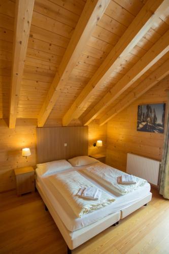 a bedroom with a large bed in a wooden ceiling at Feriendorf Koralpe Chalet Edelweiss in St. Gertraud