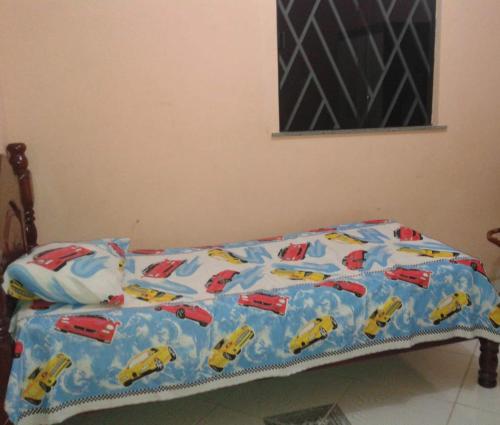 Una cama con un edredón con coches encima. en Casa grande com 4 quartos e área de serviços e lazer, en Bragança