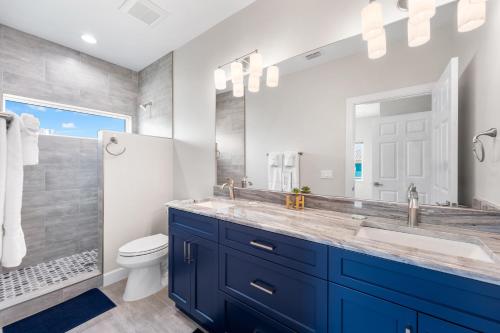 a bathroom with a blue sink and a toilet at Mid Island Beach Getaway - Close to Beach, Heated Pool - Suntide - Roelens in Fort Myers Beach