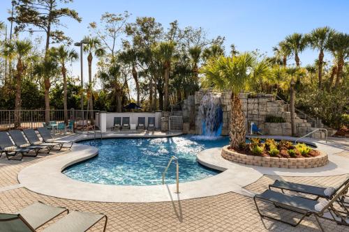 a swimming pool with a waterfall in a resort at Crowne Plaza Orlando - Lake Buena Vista by IHG in Orlando