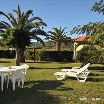 two white chairs and a table in the grass at Casale Conci in Casa Ajali