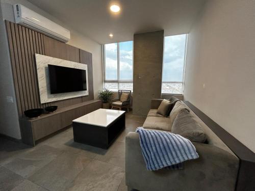 a living room with a couch and a tv at Departamento de Lujo, en el centro de Mty in Monterrey
