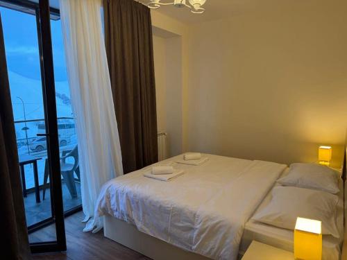 a bedroom with a bed and a large window at Very cozy 2 Room apart NEW GUDAURI, LOFT 2, apt 223 in Gudauri