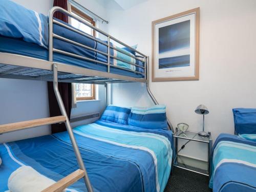 a bedroom with two bunk beds with blue sheets at PNJ Long Stay Central Manchester Accommodation in Manchester