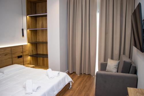 a hotel room with a bed and a chair at BB The Garden in Durrës