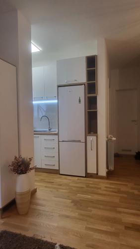 a kitchen with a white refrigerator in a room at Konatar Apartmants in Kruševac